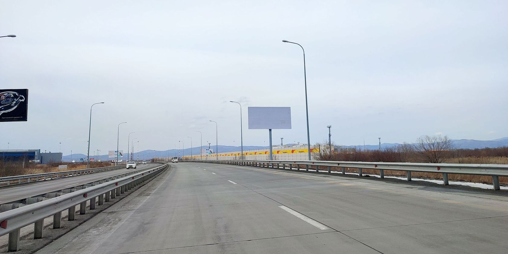 Фотография рекламного носителя, тип: Билборд 3x6, адрес: подъезд к аэропорту Кневичи а/д, 1 360м, справа, Владивосток, Приморский край, Россия. Сторона А №974839