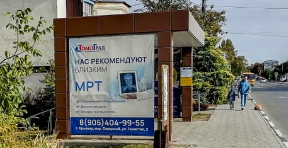 Фотография рекламного носителя, тип: Остановка 1.8x1.2, адрес: Ленинградская ул., д.7, Гулькевичи, Краснодарский край, Россия. Сторона В1 №1375433