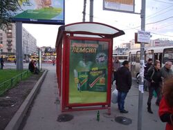 Фотография рекламного носителя, тип: Остановка 1.8x1.2, адрес: Большевиков ул. Х Дыбенко ул., д.27, Санкт-Петербург, Россия. Сторона Б №130439