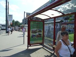 Фотография рекламного носителя, тип: Остановка 1.8x1.2, адрес: Большевиков ул. Х Дыбенко ул., д.27, Санкт-Петербург, Россия. Сторона А №130438